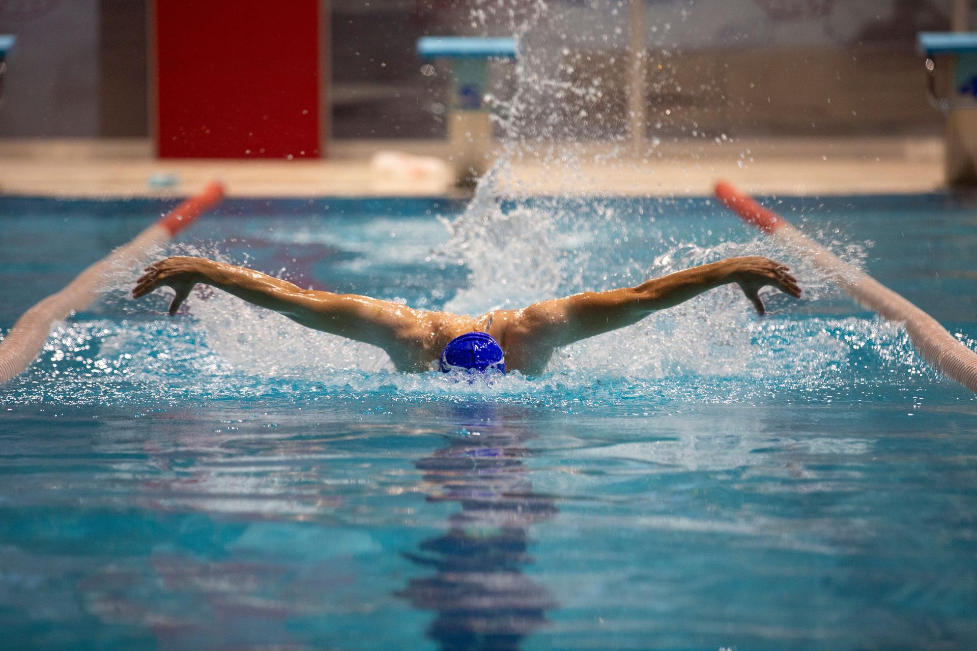 A skilled athlete showcases the butterfly stroke in an Olympic-sized pool.