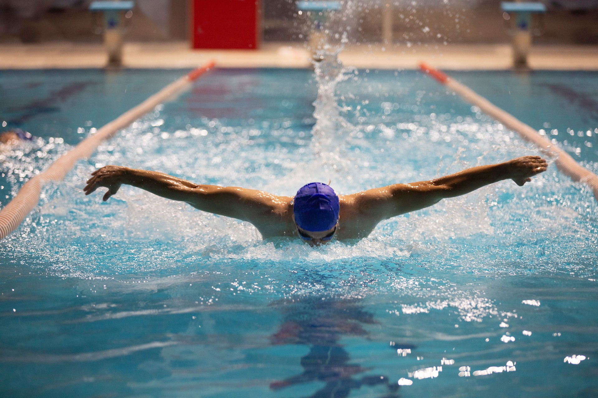 A skilled athlete showcases the butterfly stroke in an Olympic-sized pool.